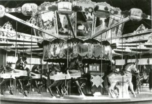 Historic image of the Murphy Brothers carousel, circa 1905, featuring intricately carved horses and a zebra under a detailed canopy.