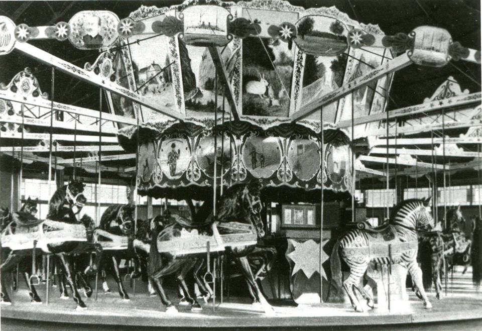 Historic carousel at Lost Park, featuring intricately painted panels and a variety of ornate horses and zebras.