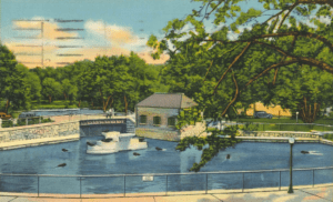 A vintage postcard of the Seal House at the Pittsburgh Zoo, featuring seals in a pool, surrounded by trees and a small building.