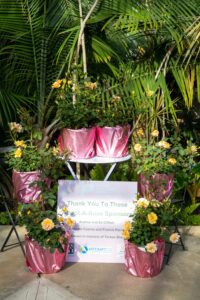 Potted roses with a sign thanking Adopt-A-Rose sponsors: Audrey and Ed Clifton, Gonzalo Cuervo and Francis Parra, and Drown in memory of Teresa Sheehan.