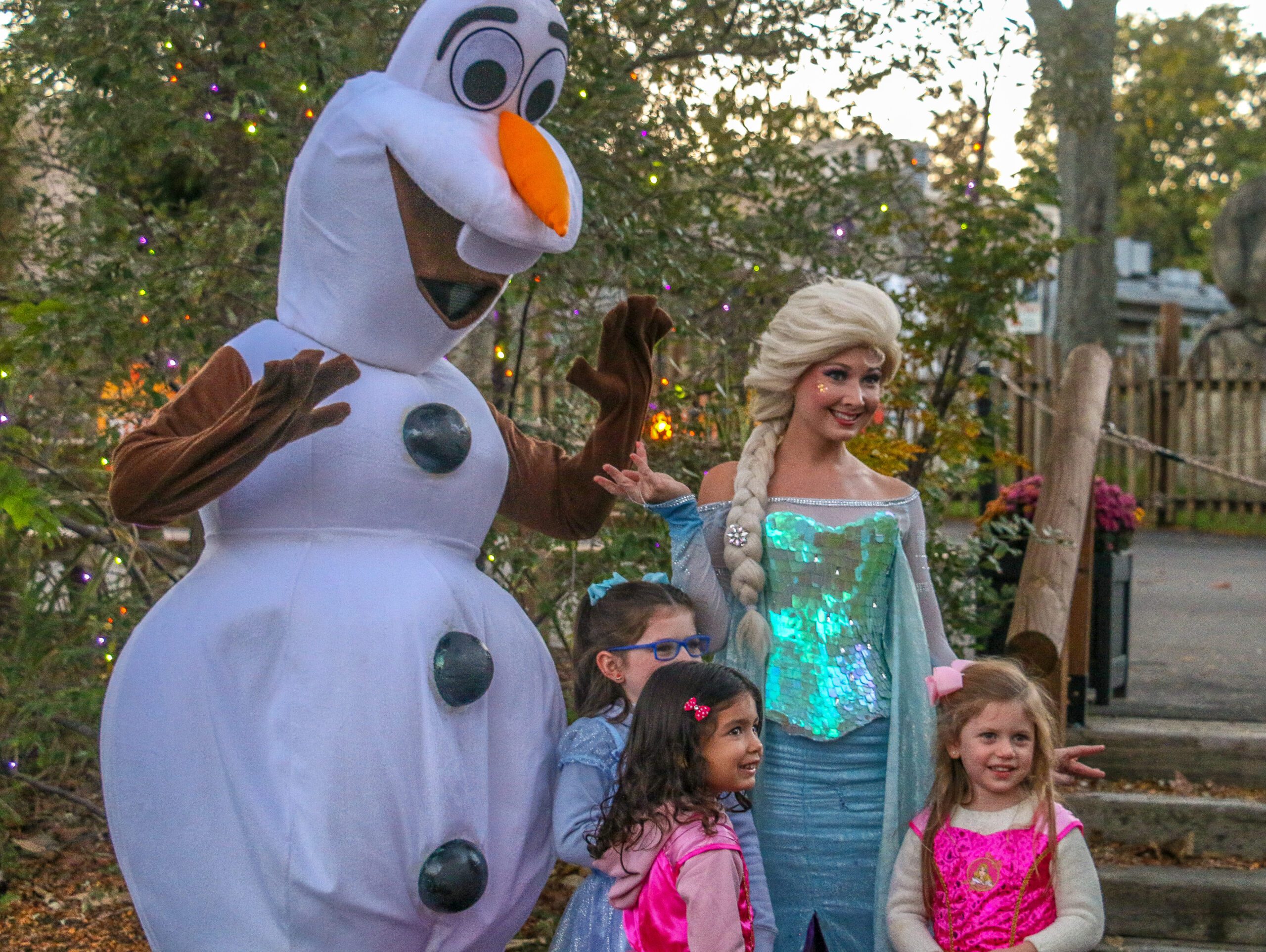 Olaf and Elsa from "Frozen" pose with three smiling children in colorful outfits during Family Fun Night at JOLS.